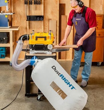 Running lumber through a benchtop planer with dust collection system