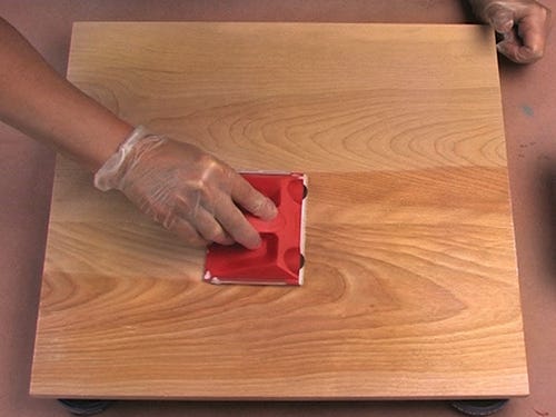 Using a paint pad to smoothly spread varnish finish