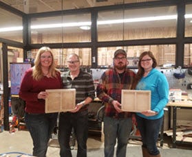 two couples display their completed woodworking projects