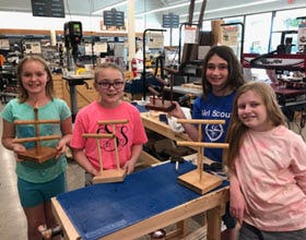 group of four young girls showing their handmade jewelry tree's