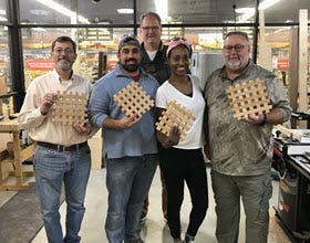 group of people showing off their completed woodworking projects