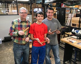 three generations of men showing off their handmade handles