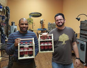 two men holding bottle caddys